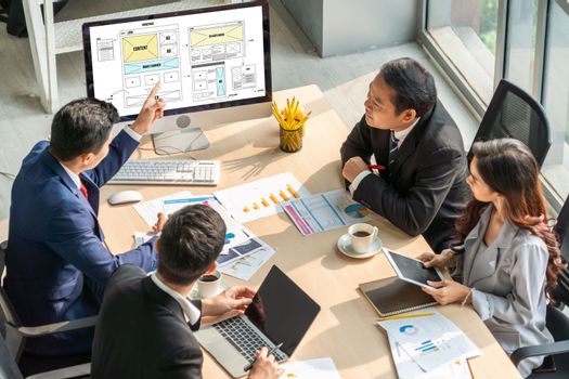 Smart businessman and businesswoman talking discussion in group meeting at office table in a modern office interior. Business collaboration strategic planning and brainstorming of coworkers.