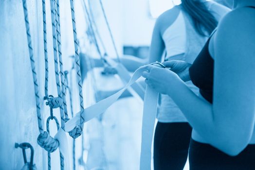 Yoga ropes hanging on studio wall. White background. Iyengar yoga props