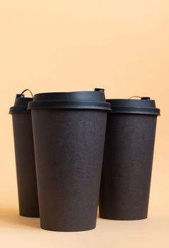 Set of three takeaway black coffee cup on neutral background. Mock -up, nobody, front view, 