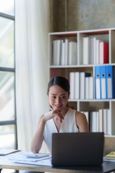 Asian Business woman working at home office and analyze financial report document. Accounting and Finance concept.