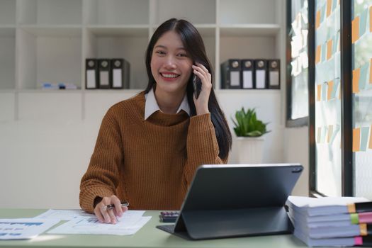 Asian Business woman working at home office and analyze financial report document. Accounting and Finance concept.