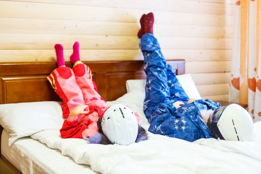 mother and daughter rest on bed after skiing