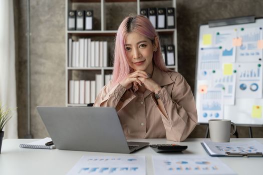 Asian Business woman working to analyze technical price graph and indicator with business team talking by cell phone. account or saving money or insurance concept.