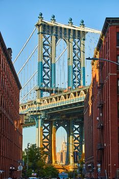 Image of Sunny Manhattan Bridge from Brooklyn New York City between two brick buildings