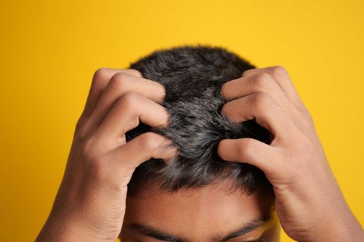 teenage boy Scratching Head Against black background 