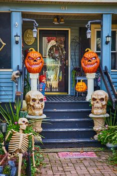 Image of Pumpkins and skeletons for Halloween decorate exterior of American house porch in New York