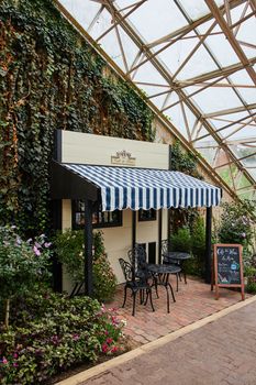 Image of Tiny French shop cafe created inside of botanical gardens with glass ceiling