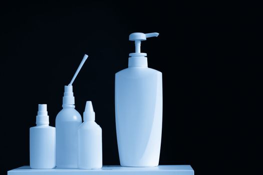 Bottles of hand sanitizers and liquid soap on a black background