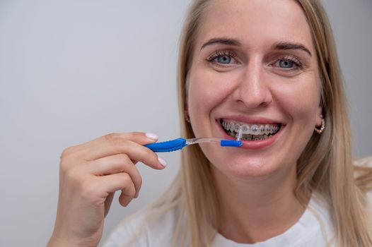 Caucasian woman cleaning her teeth with braces using a brush