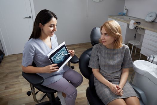 Doctor dentist showing patient's teeth on X-ray