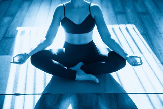 Young woman meditating sitting in lotus position