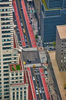 Image of Looking down on New York City intersection with red and black lanes and lined with skyscrapers