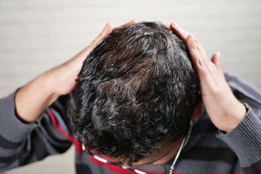 hair loss concept with man checking his hair .