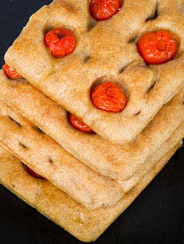 Italian flat bread organic wholewheat focaccia with tomatoes isolated in studio over a background