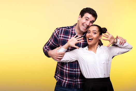 Man and woman in studio having fun on yellow background