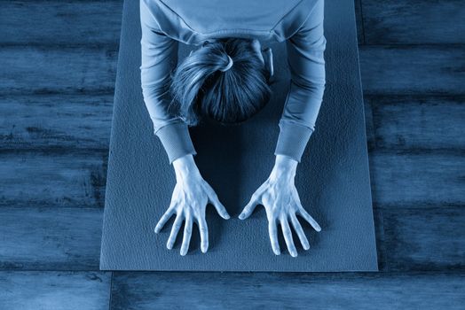 Portrait of a beautiful young woman sitting in yoga pose at the beach