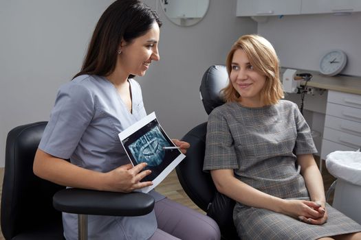 Doctor dentist showing patient's teeth on X-ray