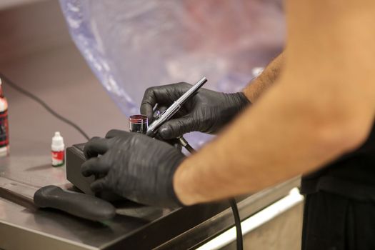 cook preparing a red frosted cake using air bush