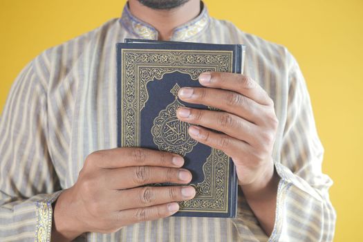 muslim man hand holding Holy book Quran with copy space ,