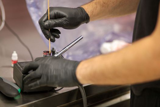 cook preparing a red frosted cake using air bush
