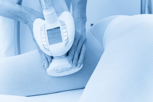 Woman in special white suit getting anti cellulite massage in a spa salon. LPG, and body contouring treatment in clinic