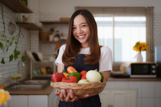 Portrait of beautiful young asian woman making salad at home. cooking food and Lifestyle moment.