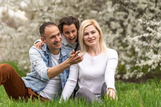 Family and small child outdoors in spring nature, resting