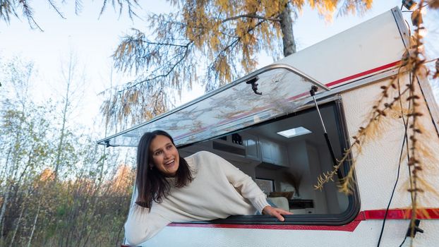 Caucasian woman peeking out of camper window