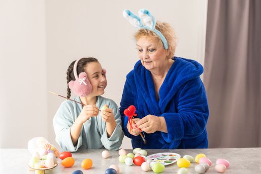 family grandmother and child granddaughter with ears hare getting ready for holiday, easter.