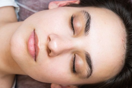 Woman lying on the couch after eyelash lamination procedure