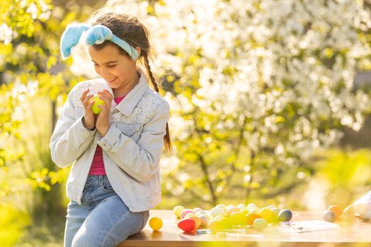 Teenage girl holding easter eggs in the backyard.