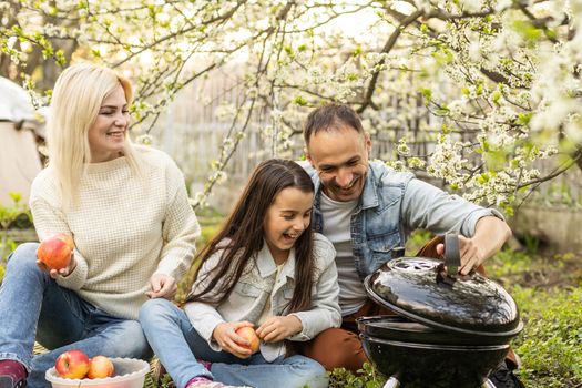 Happy family having barbecue with modern grill outdoors.