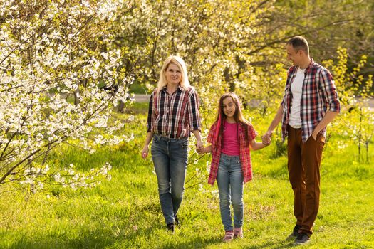 Happy young family spending time together outside in green nature.