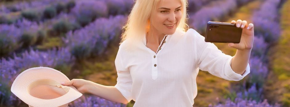 woman taking photo with mobile cell phone in the lavender field.