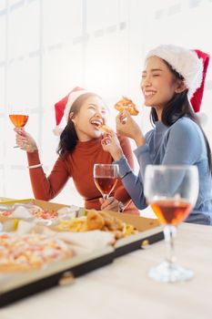 Friends at birthday party clinking glasses with champagne and pizza, enjoying Christmas vacation, pizza on the table. Holiday Party event.