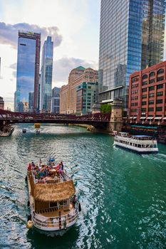 Image of Tropical tourist ship through Chicago river canals by bridge lined with skyscrapers