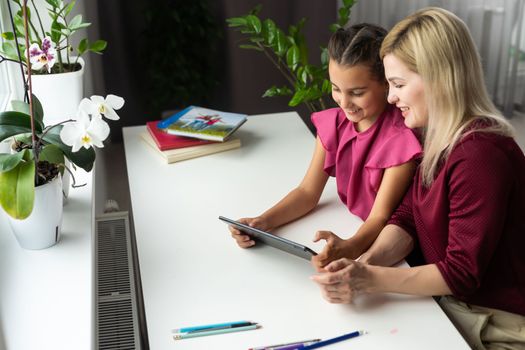 Mom with her tween daughter using tablet together