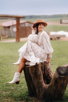 Beautiful girl in vintage lace dress and hat at the ranch.