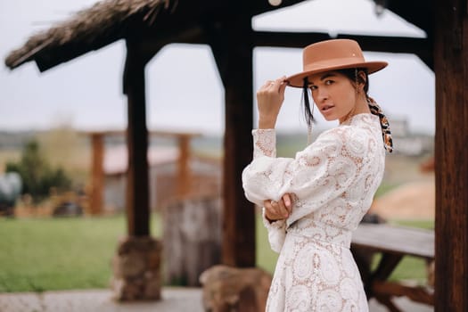 Beautiful girl in vintage lace dress and hat at the ranch.