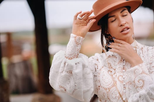 Beautiful girl in vintage lace dress and hat at the ranch.