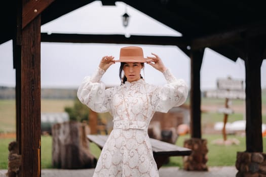 Beautiful girl in vintage lace dress and hat at the ranch.