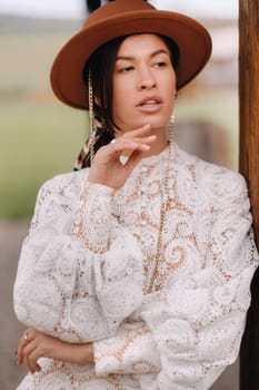 Beautiful girl in vintage lace dress and hat at the ranch.