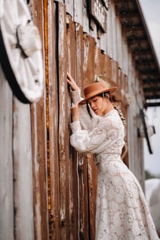 Beautiful girl in vintage lace dress and hat at the ranch.