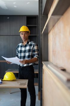 Architect man working with blueprints for architectural plan, engineer sketching a construction project, green energy concept.