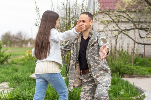 military reunion between father and daughter. military dad embracing his daughter on his homecoming. Army soldier.