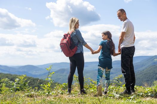 Happy family: mother, father, child daughter on nature.