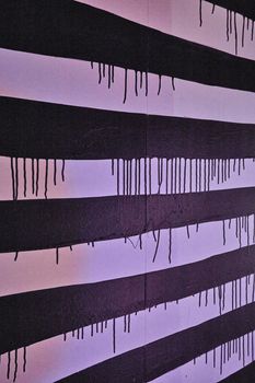 Image of Black and white stripes on wall with dripping black paint