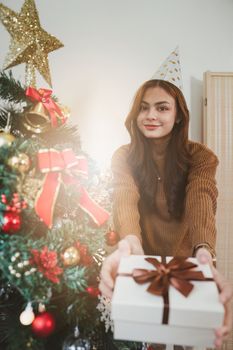 Cheerful lady surprised of the present after the opening in the gift box. Marry Christmas and Happy Holidays and New Year eve celebrating concept.