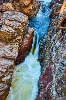 Image of Deep stone gorge with river rapids and intense waterfall flowing through