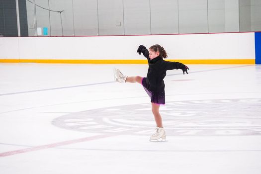 Little girl practicing before her figure skating competition at the indoor ice rink.